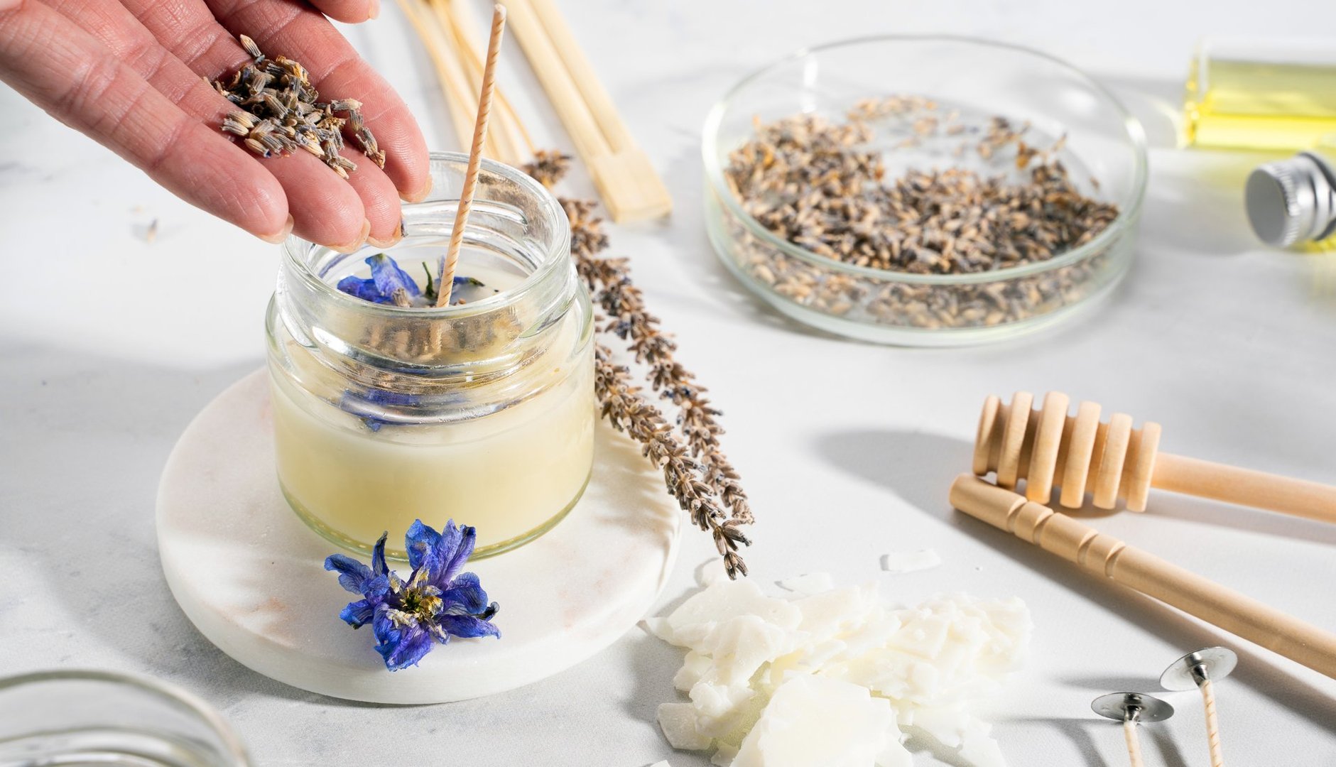 Set tools for homemade natural eco-friendly soy wax candles, wick, perfume, essential oil on a marble table. Making process. Trendy DIY. Craft hobby, small business, artisan products concept.