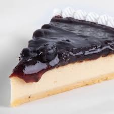 Slice of blueberry cheesecake with a glossy blueberry topping and a decorative whipped cream edge.