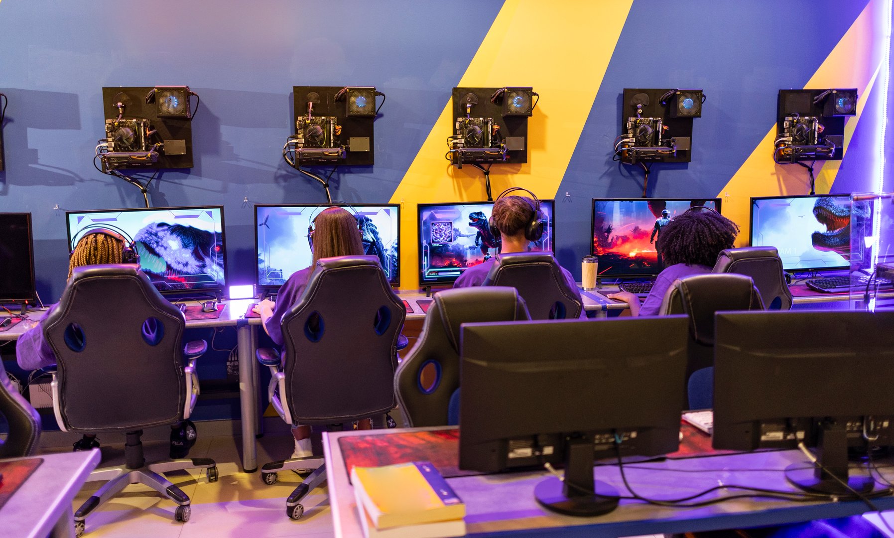 A group of gamers is deeply engrossed in a competitive video game battle at a gaming event.