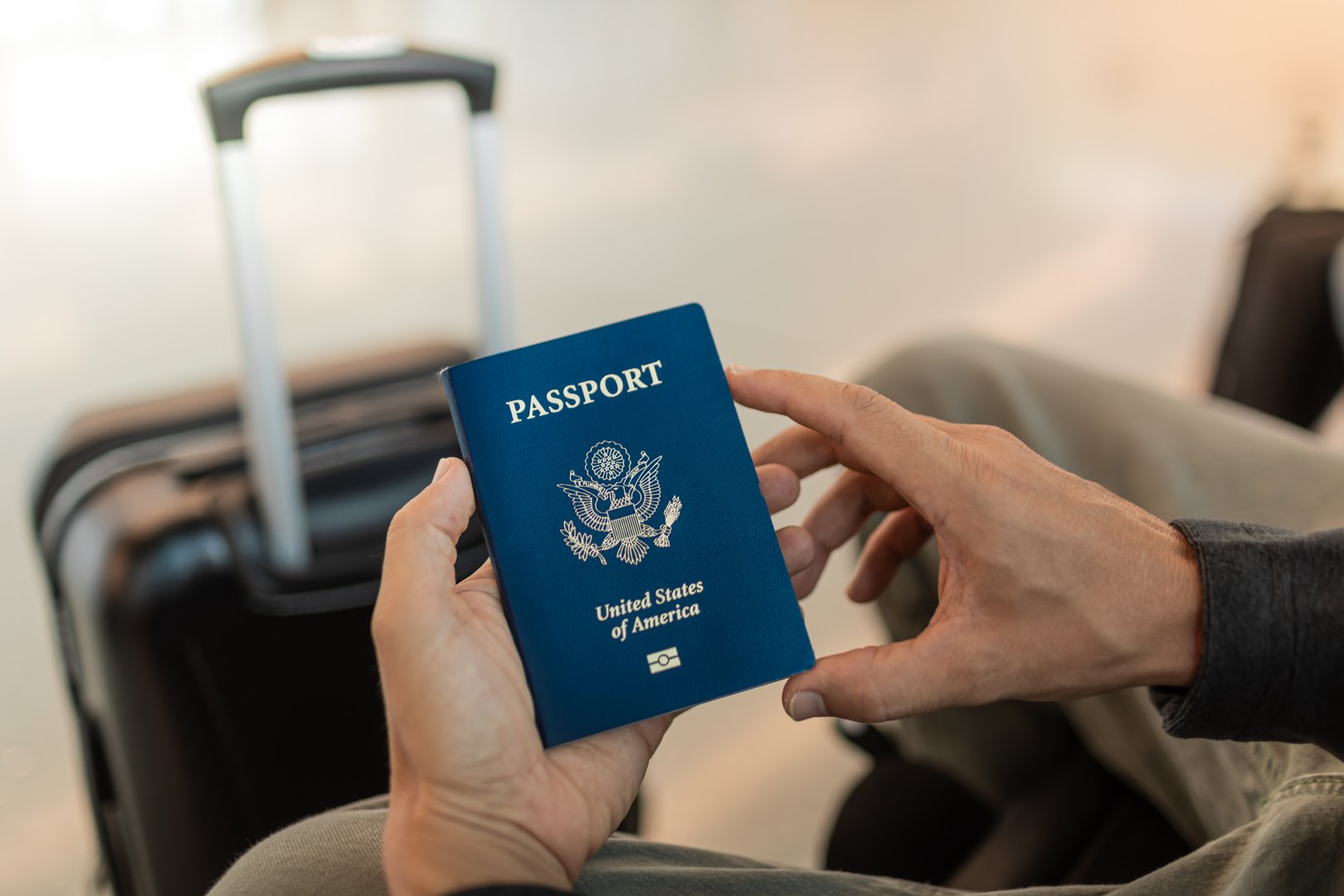 Traveler holding USA passport at the airport.