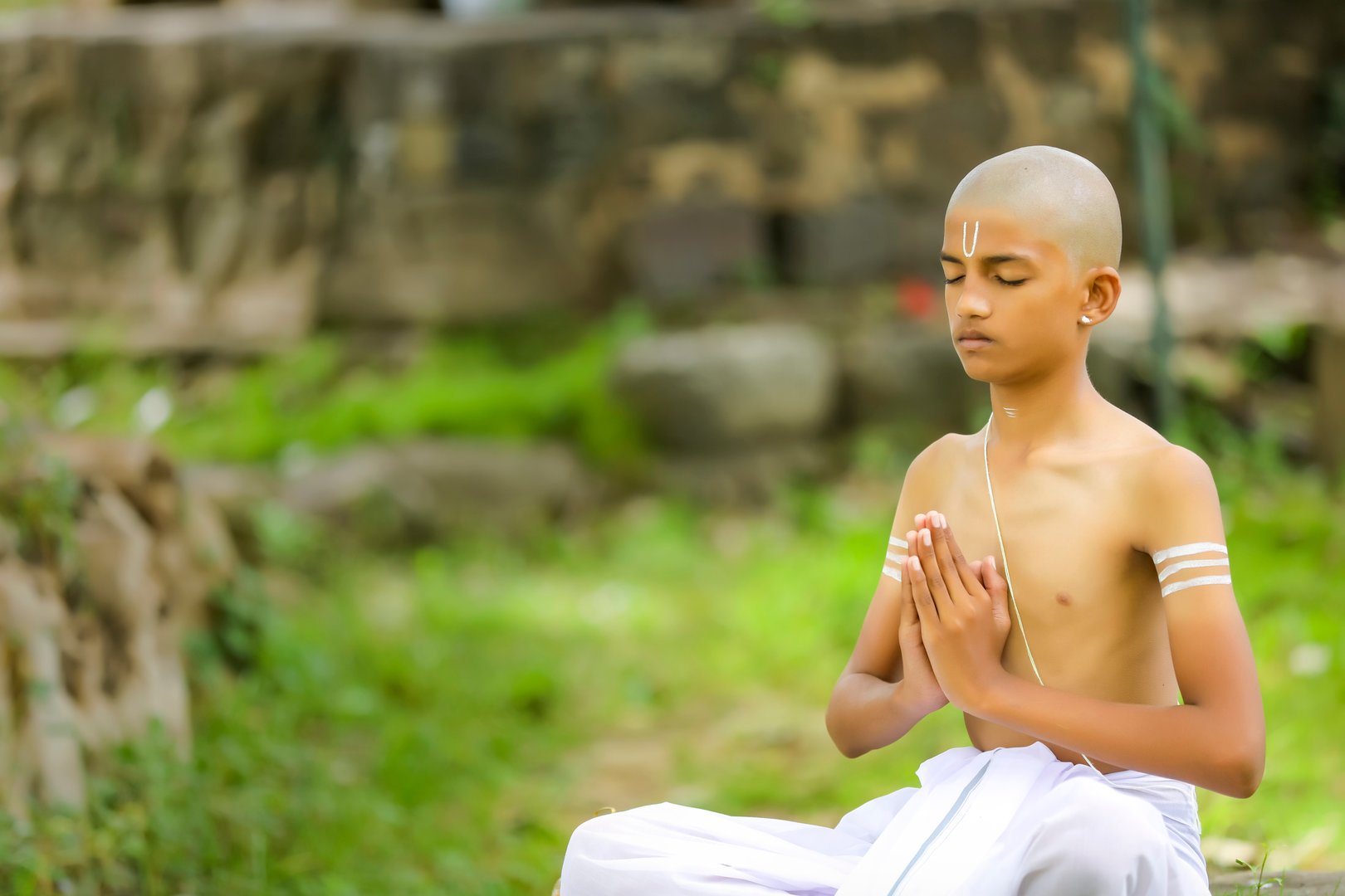 the indian priest child doing meditation