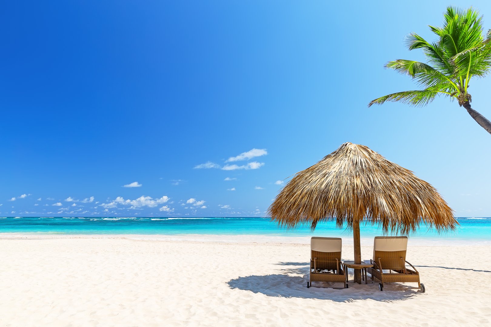 Two empty beach chairs on a summer sunny day at the beach in Punta Cana, Dominican Republic.  Amazing beach scene vacation and summer holiday concept.