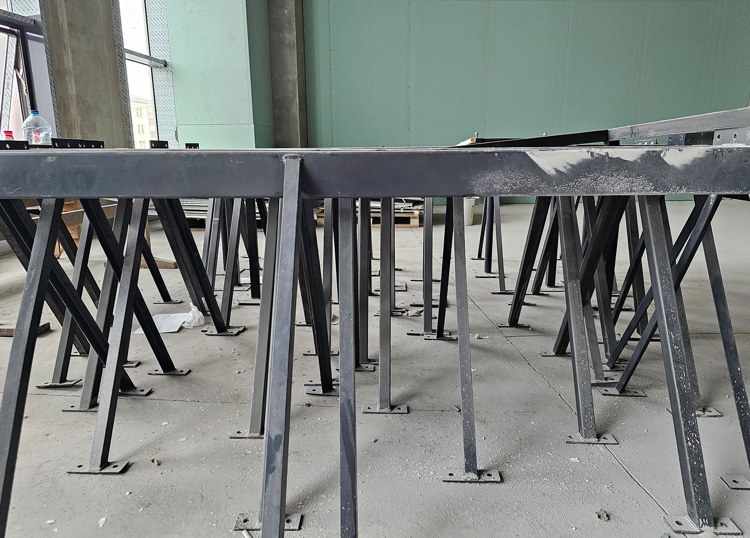 Empty industrial space showcasing a collection of metal table frames awaiting assembly during a construction project