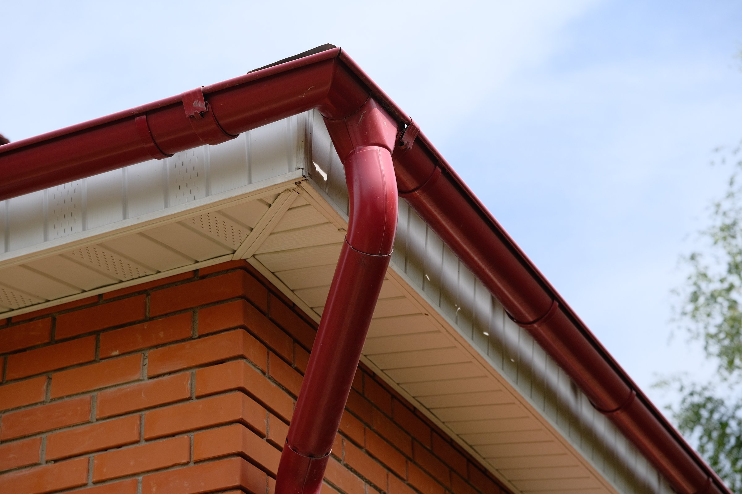 Rain gutter from roof of red brick house