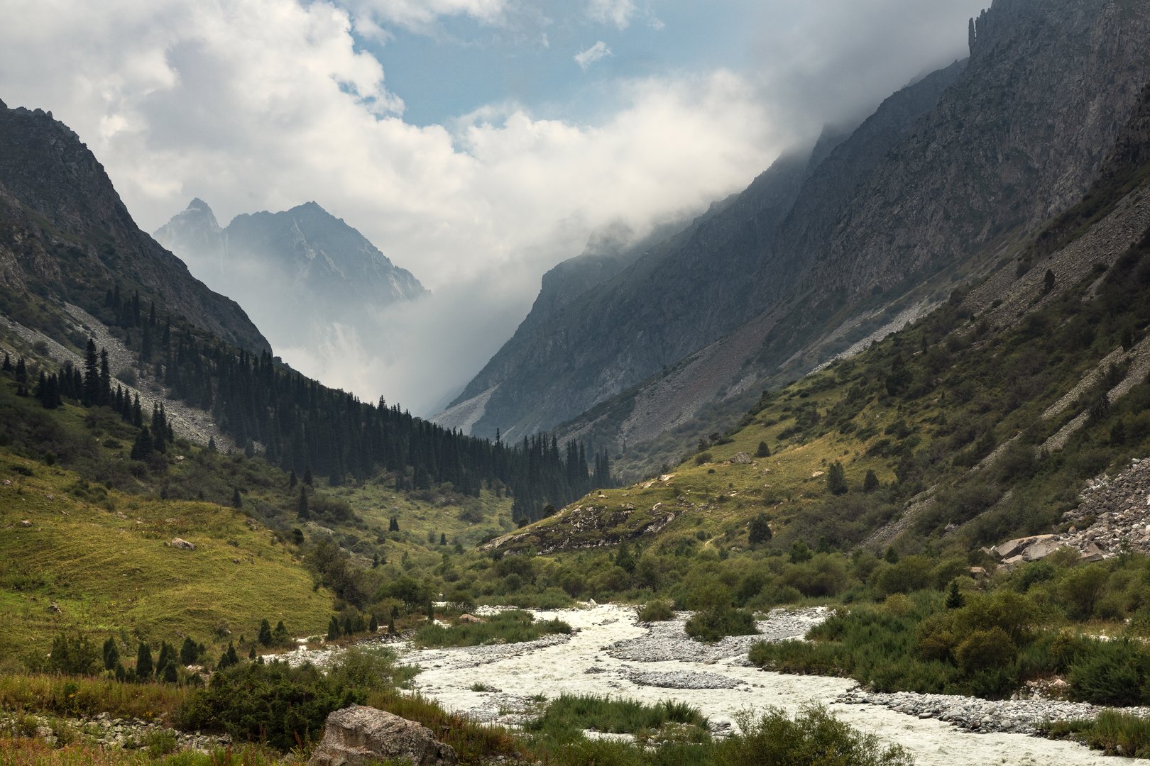 A river valley and clouds around mountains in the scenic landscape of Ala-Archa National park