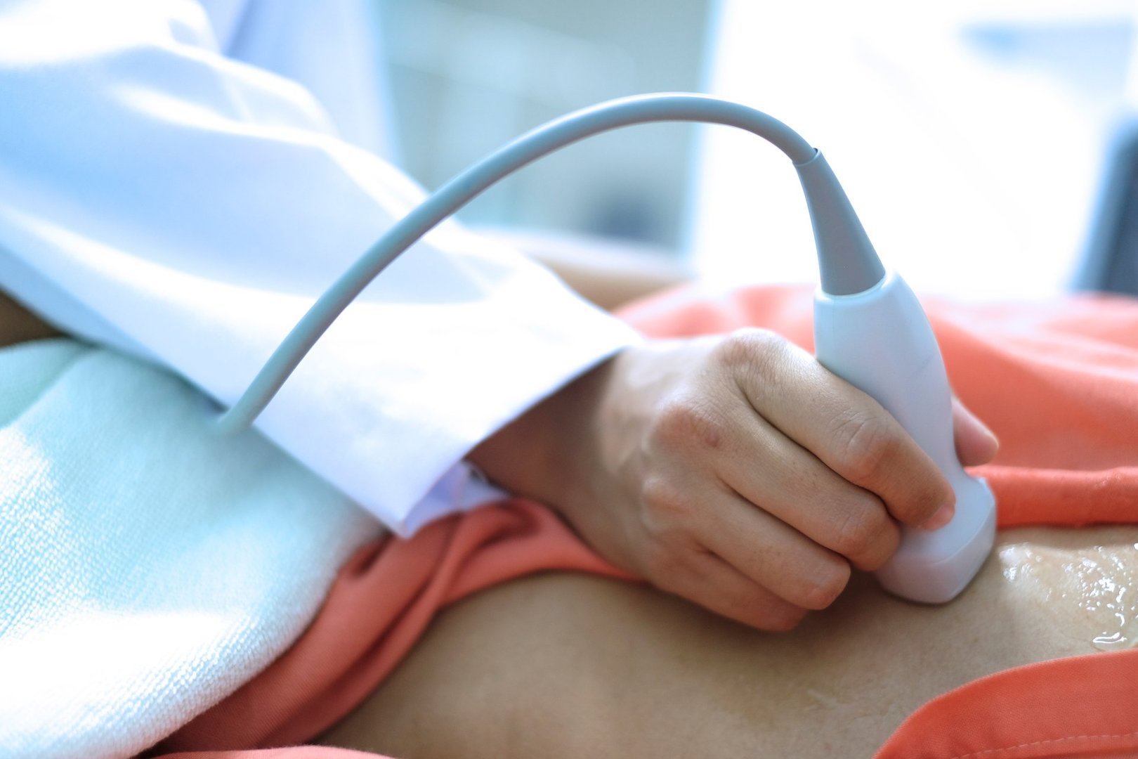 Physician making echocardiography for male patient heart, focus screen of echocardiography machine