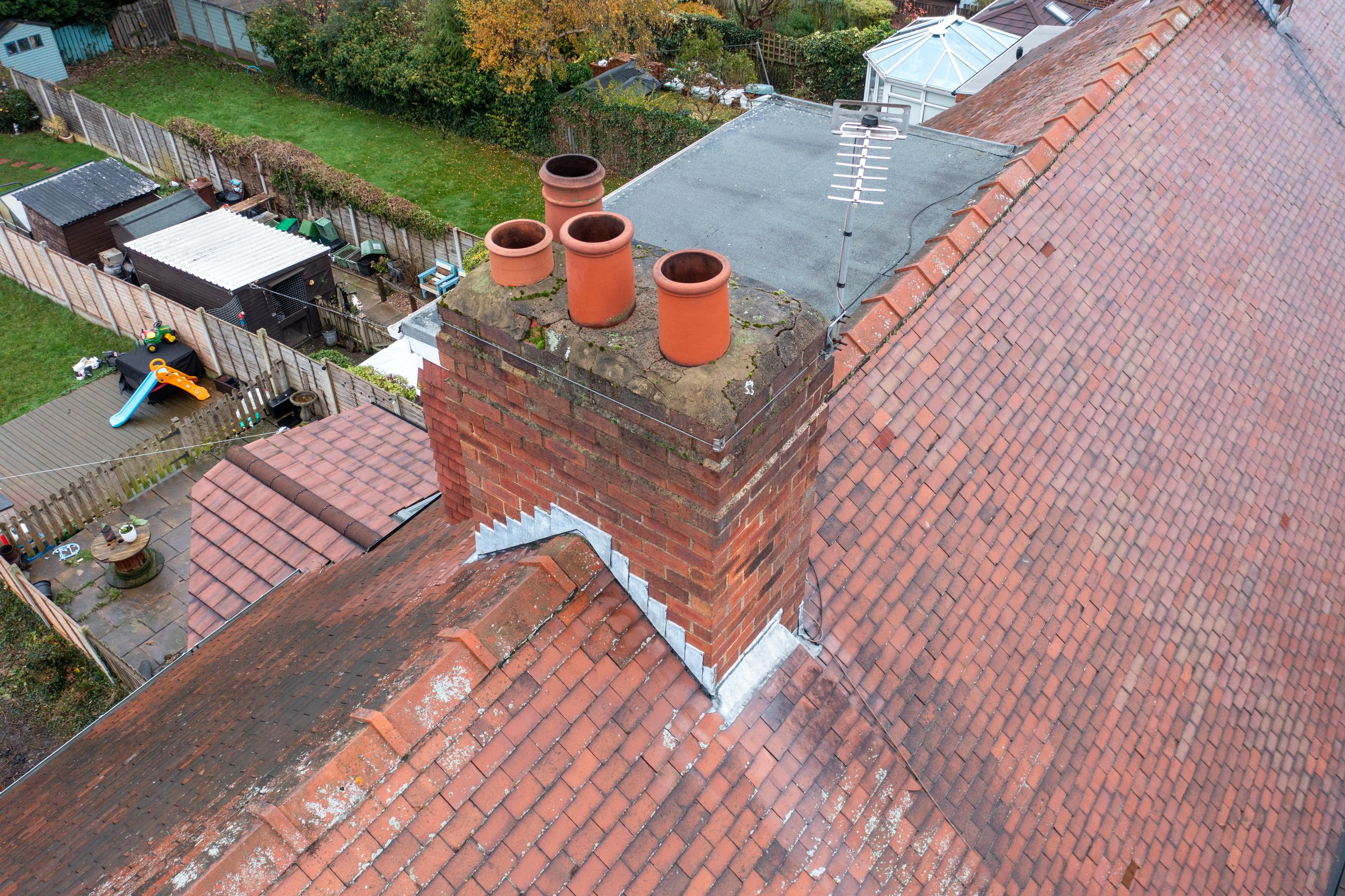 Aerial photo of a typical British terrace house in the UK showing the roof of the house and the chimney in the winter time