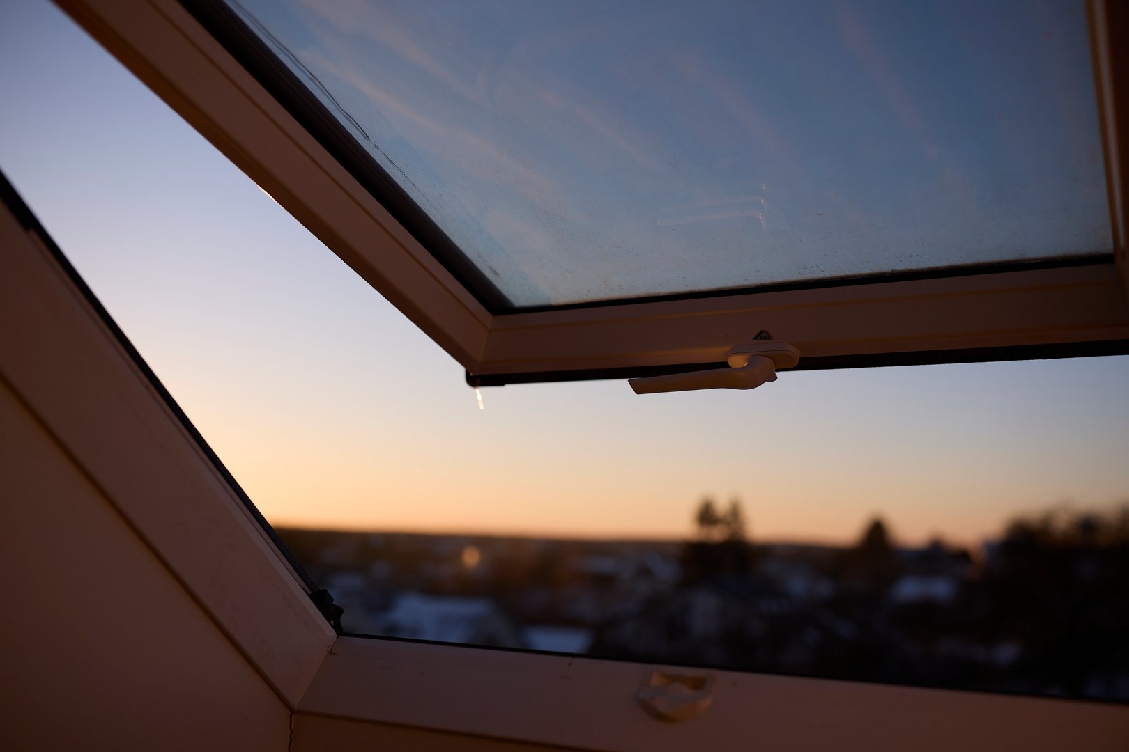 Close-up of a roof window installed in a ceiling, allowing natural light to enter the space. The image represents modern architecture, interior design, and bright living spaces. Concept of natural lighting, home decor, contemporary design, and cozy or airy atmosphere.