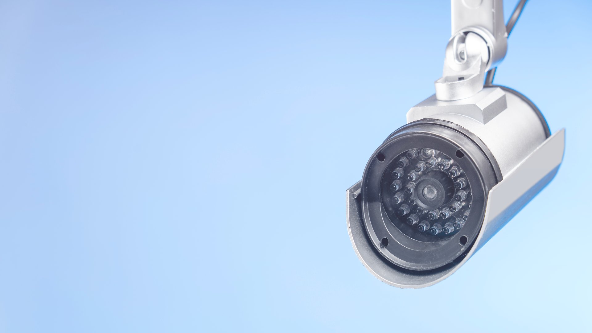 CCTV camera close-up on blue background place for text blank for design. Security system concept security artificial intelligence for the protection of public order.