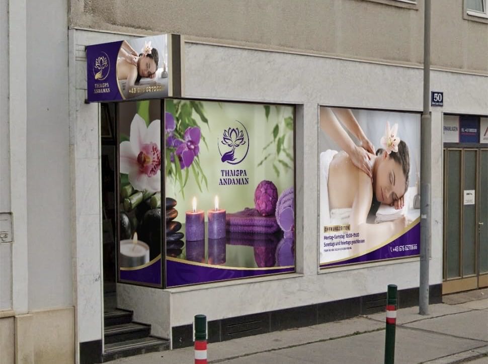 A spa storefront with images of a person receiving a massage, purple lotus logo, and contact details on the window.