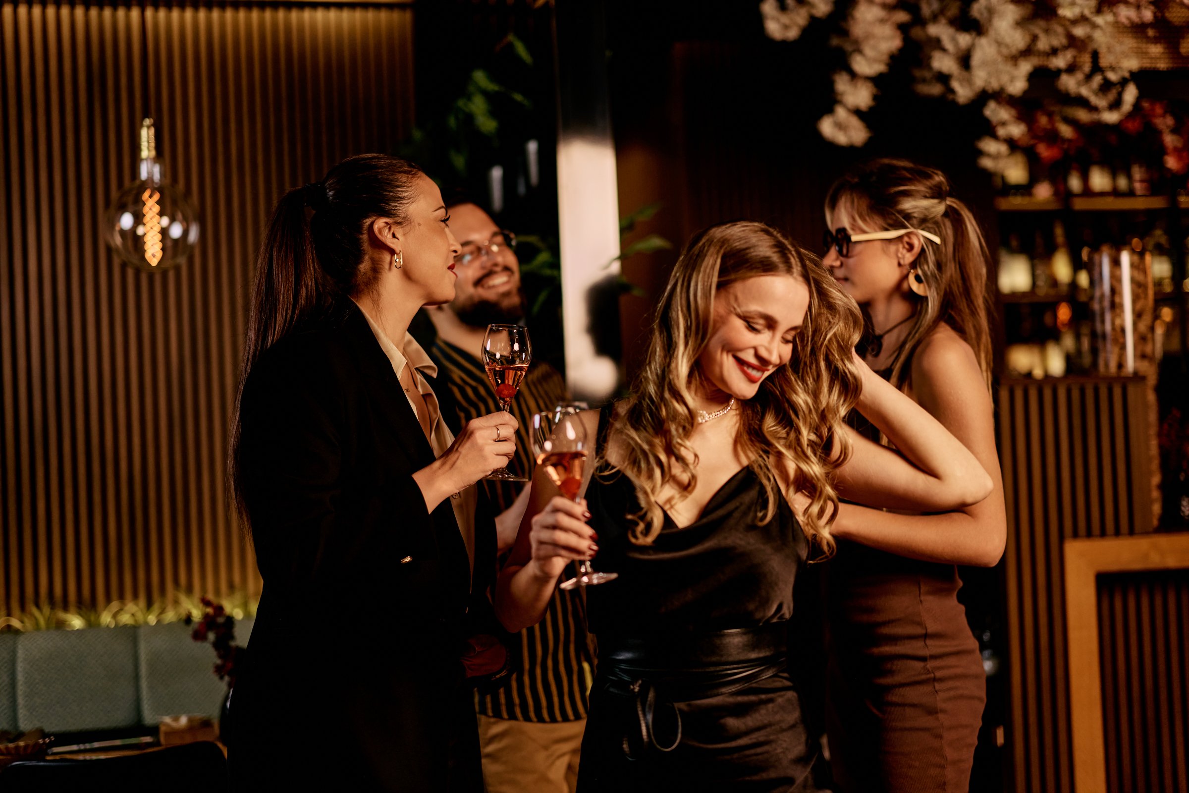 Friends gathered at a bar, laughing, enjoying drinks, and having a great time.