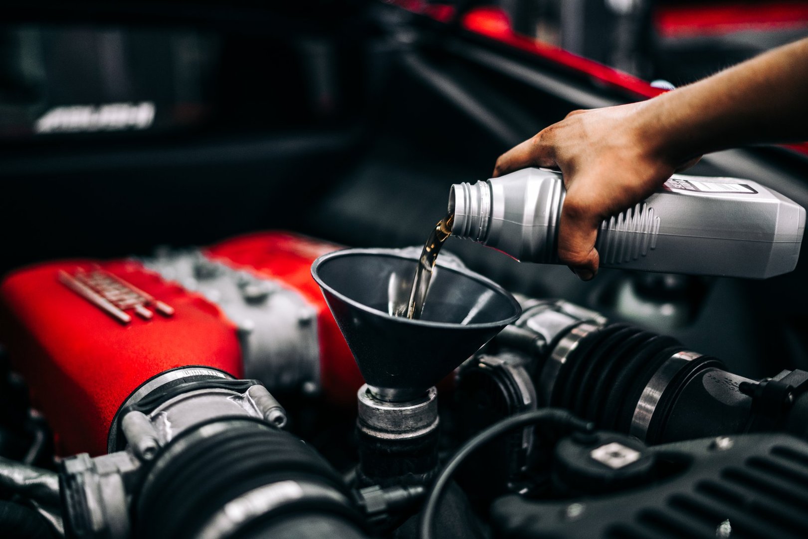 NY, NY, USA January 15, 2025 Changing the oil on a Ferrari with a hand pouring oil