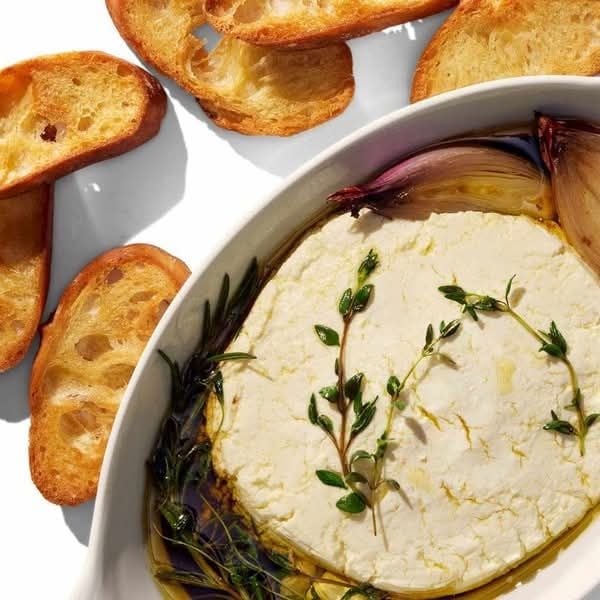 baked brie cheese with honey, grapes, aromatic herbs and crusty bread, baked camembert