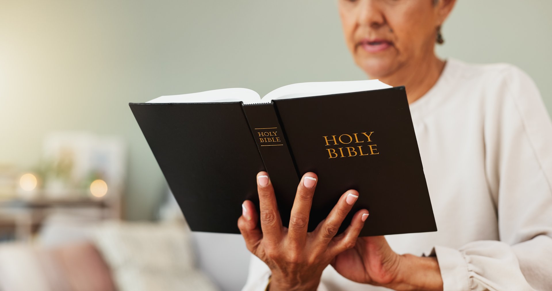 Senior woman, reading and bible in home with study, faith and religion for spiritual journey. Peace, elderly person and christian in house with devotion, gospel book and meditation for comfort.