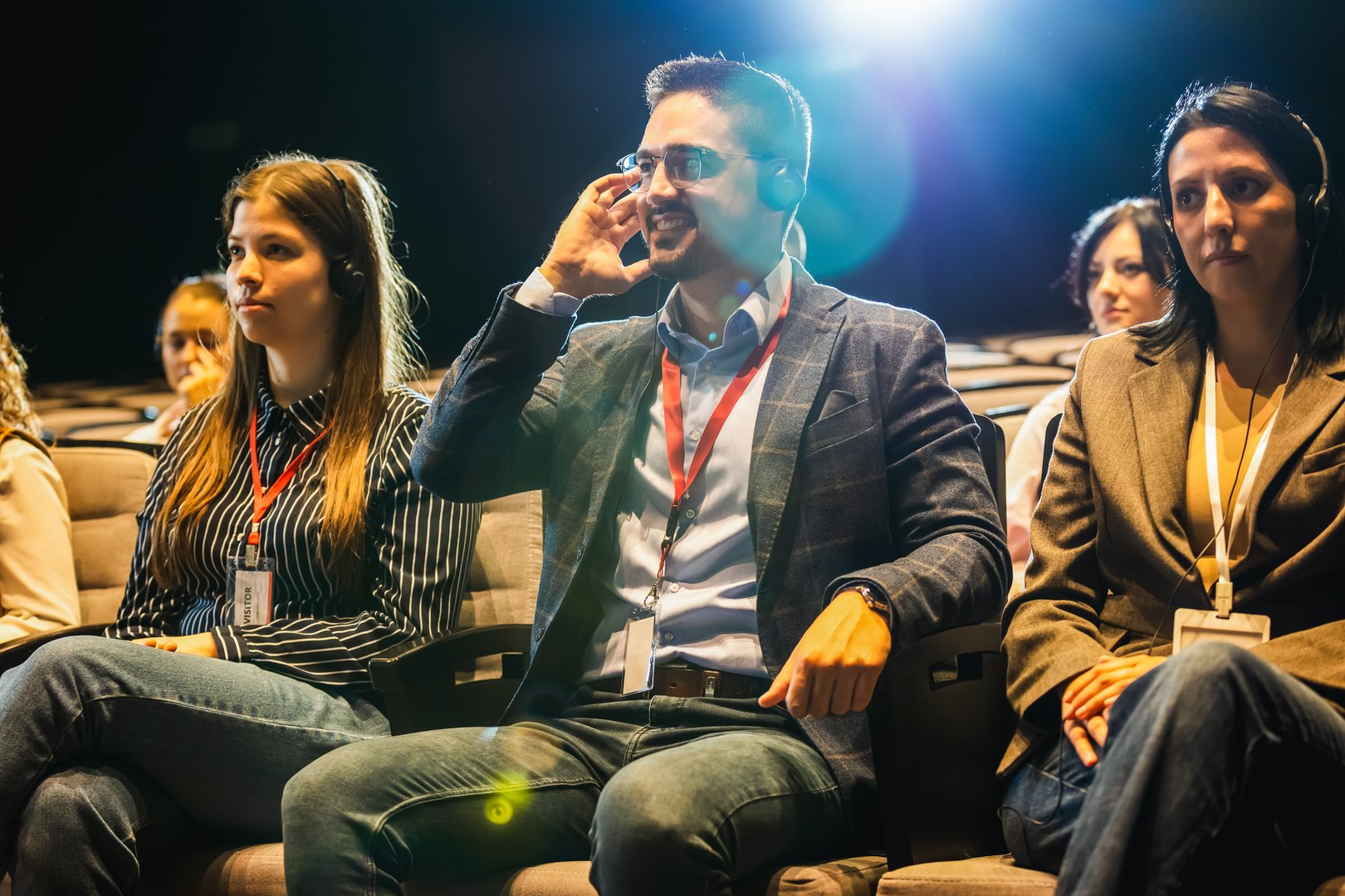 Business people wearing headphones on for translation at press conference in convention center