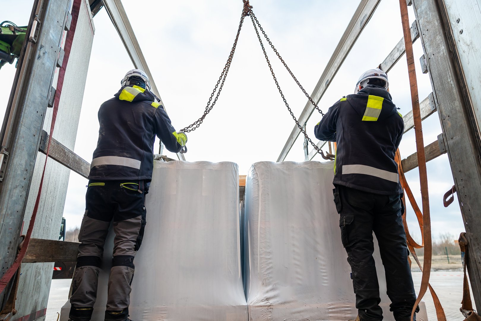 Logistics Professionals Operating a Crane to Lift Heavy Industrial Goods for Transport