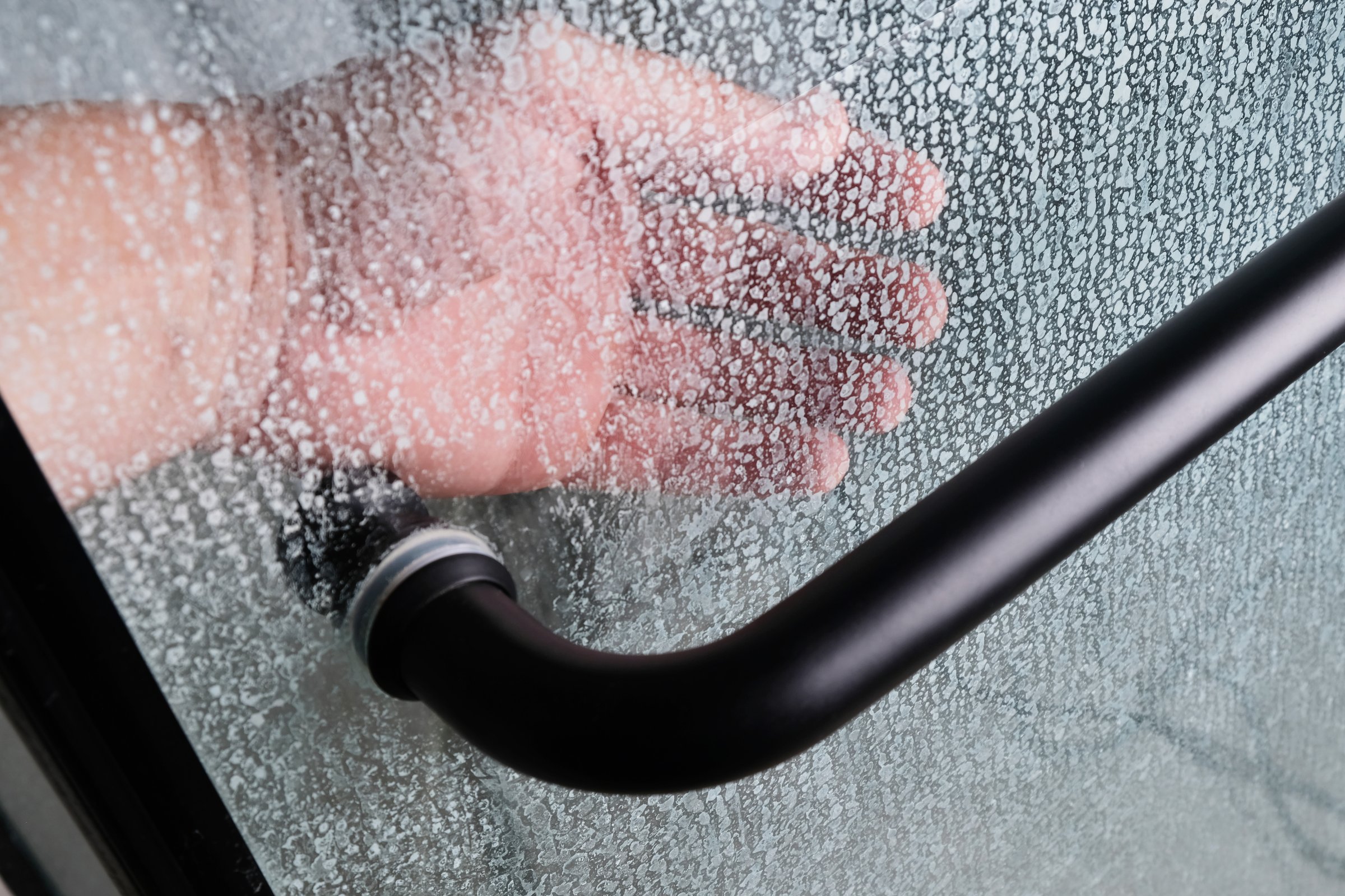 Limescale on transparent glass of shower cabin close-up, plumbing maintenance concept