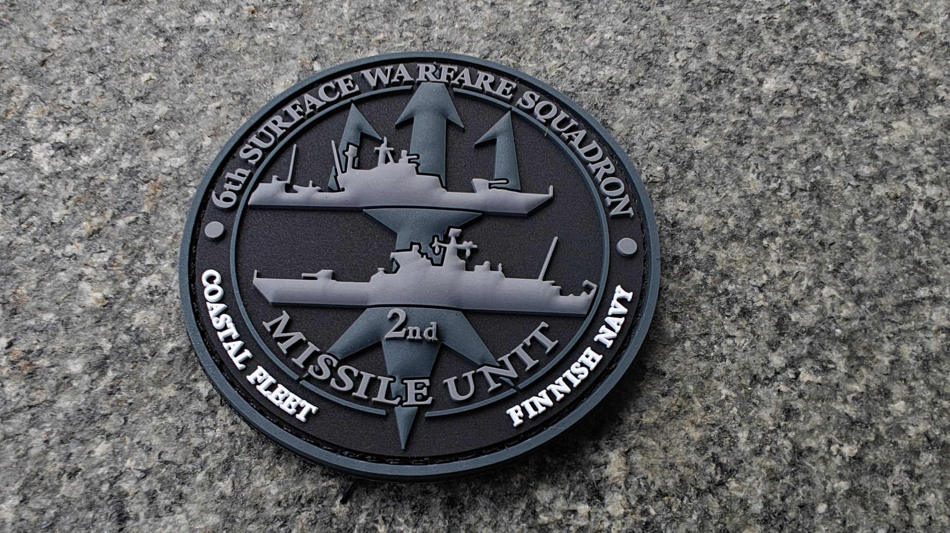 A round patch for the 6th Surface Warfare Squadron, Coastal Fleet, Finnish Navy featuring two ships and a star emblem.