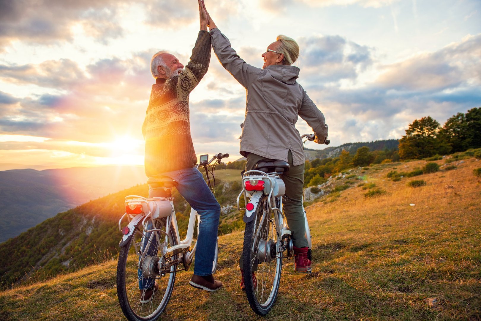 Active Senior Couple celebrating success on beautiful sunset