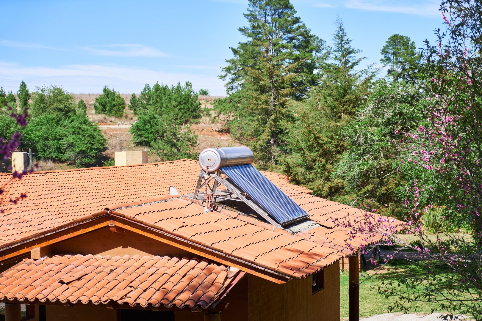 Solar water heater on roof top, cabin in the woods