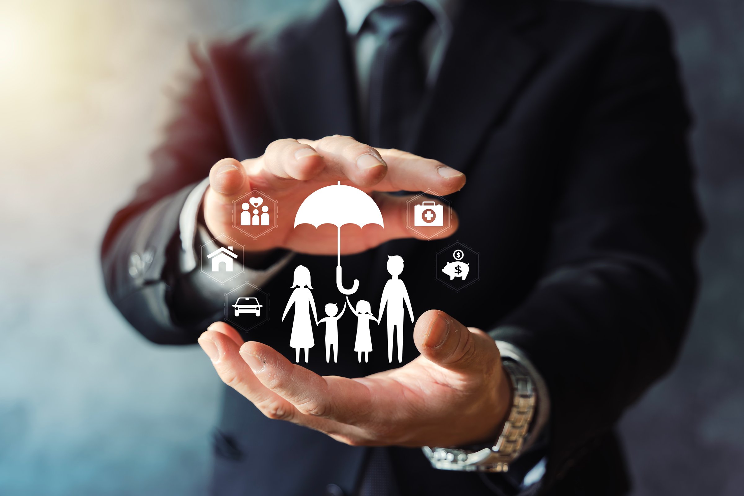 Businessman hands protecting family under umbrella with icons for health, home and car insurance. Concept of risk management, financial security, policy coverage and protection planning.