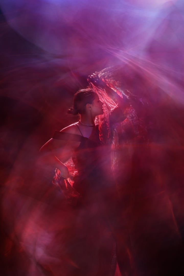 A confident female dancer is feeling the rhythm, symbilized with moving light textures.