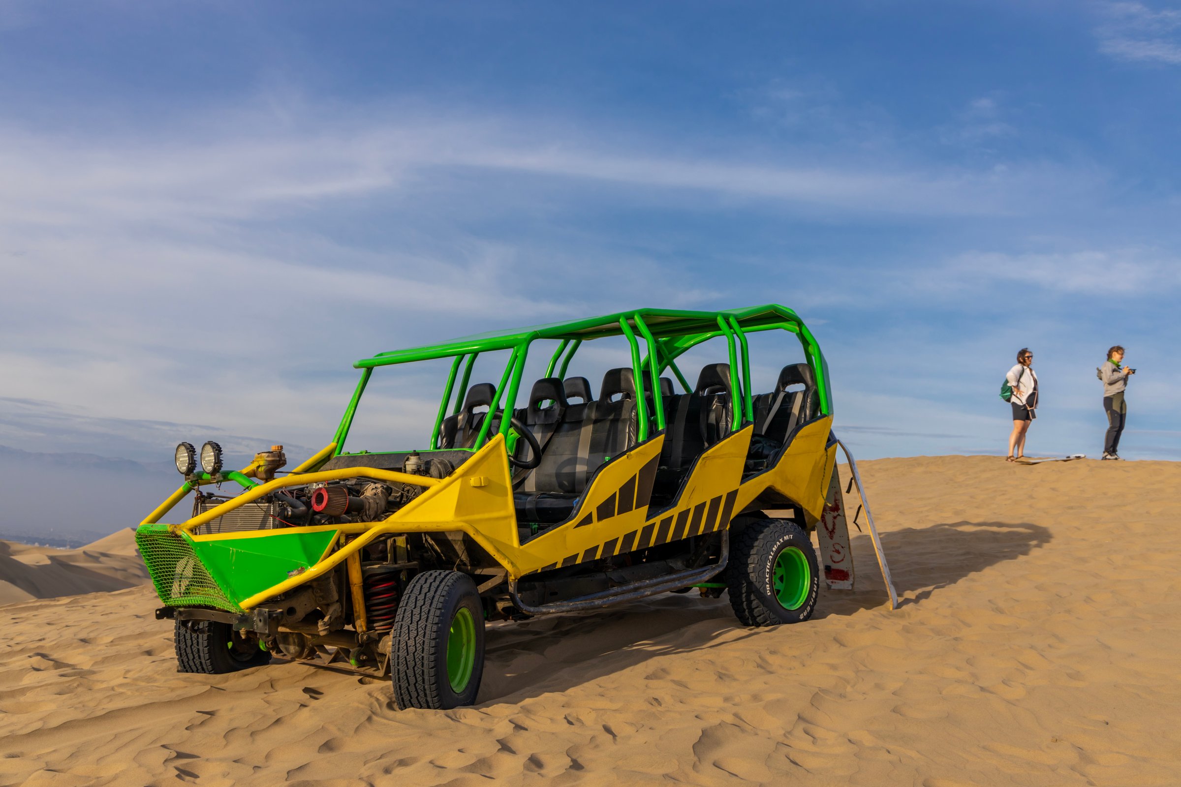 Ica, Peru - 6 June 2025: Off-road dune buggy speeding across golden sand dunes in Ica, Peru under a vivid blue sky. Adventure travel, extreme sport, desert tourism adrenaline concept with dramatic landscape Huacachina oasis