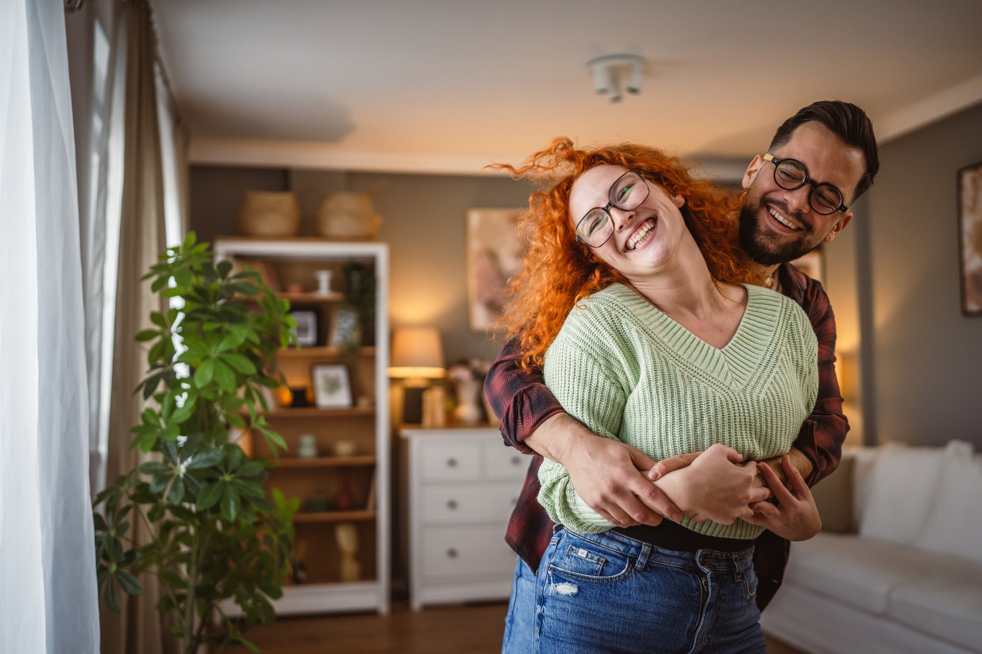man and woman couple in love dance and hug together at home