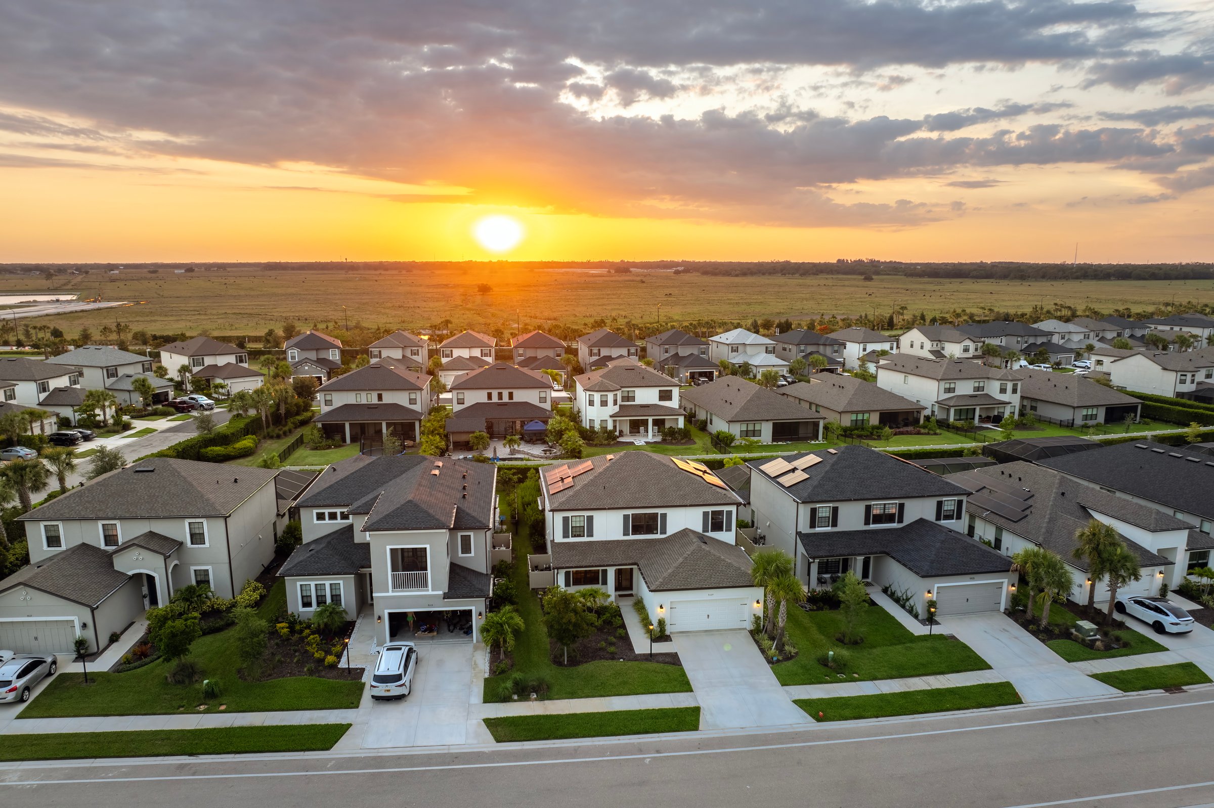 Gated community with expensive houses between green palm trees in southwest Florida. Premium housing development in the USA.
