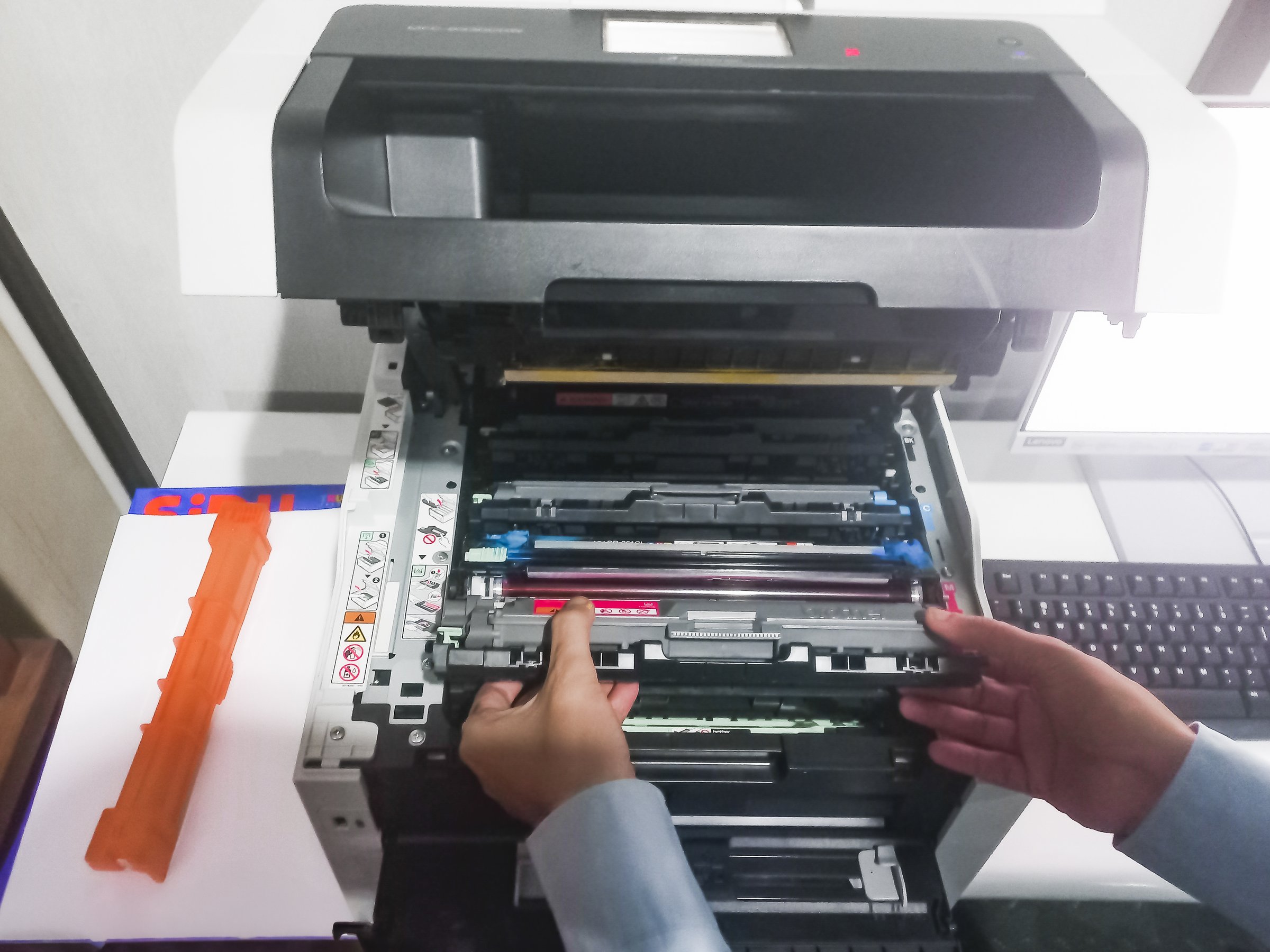 A man takes out a cartridge from a color laser printer