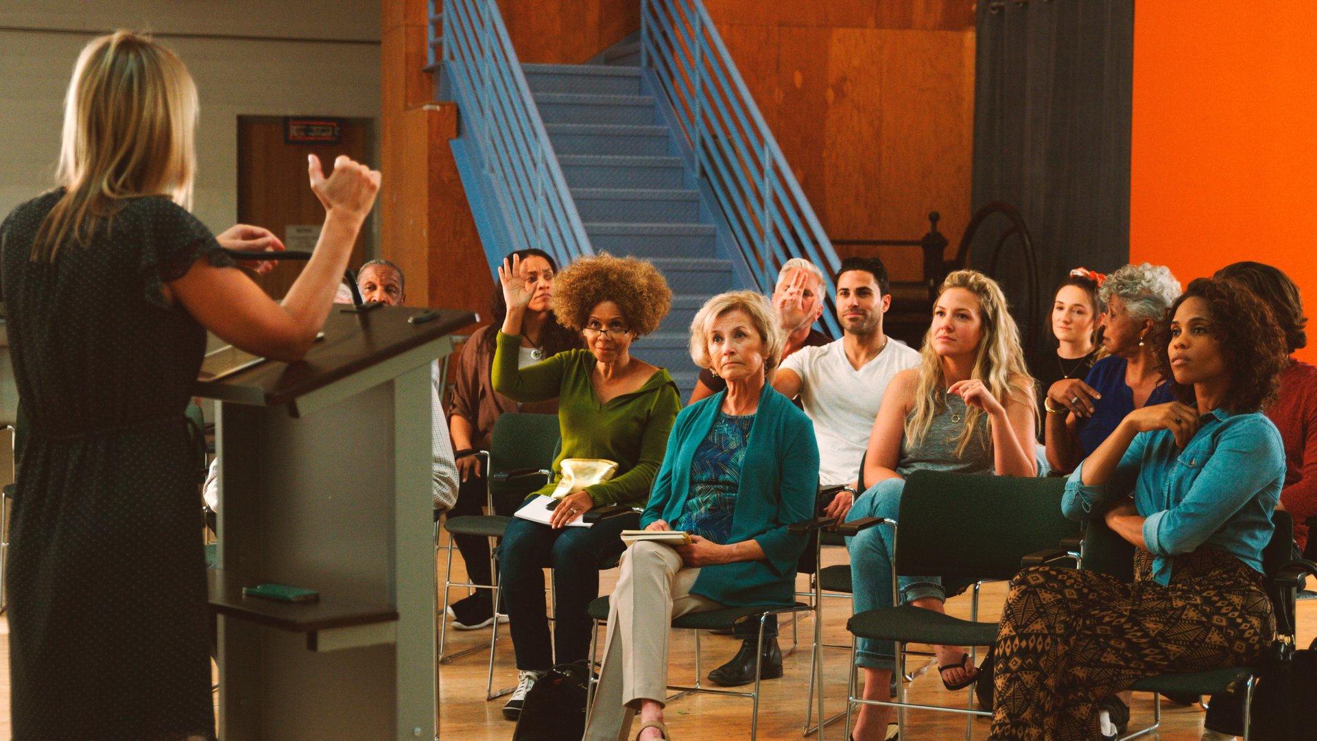 Group Attending Neighborhood Meeting In Community Center Asking Questions