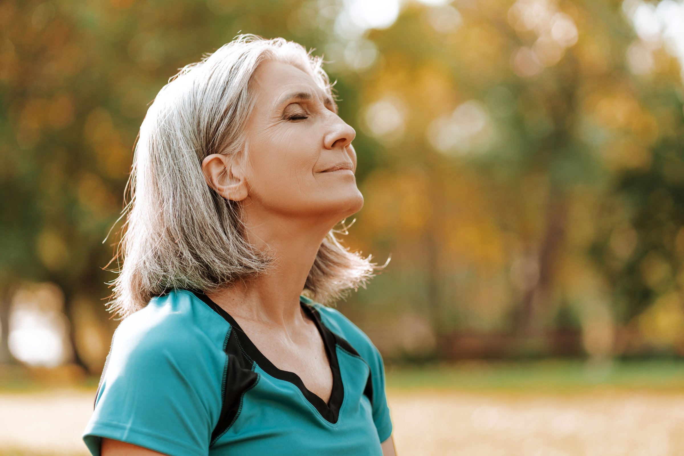 Mujer mayor practicando mindfulness al aire libre simbolizando resiliencia psicológica y longevidad