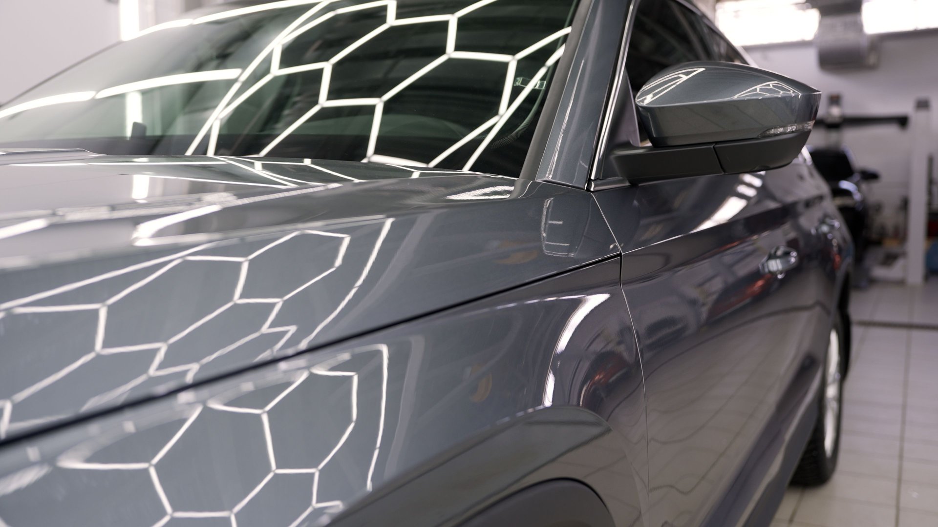 Professional automotive technicians performing detailed body repair on black vehicle