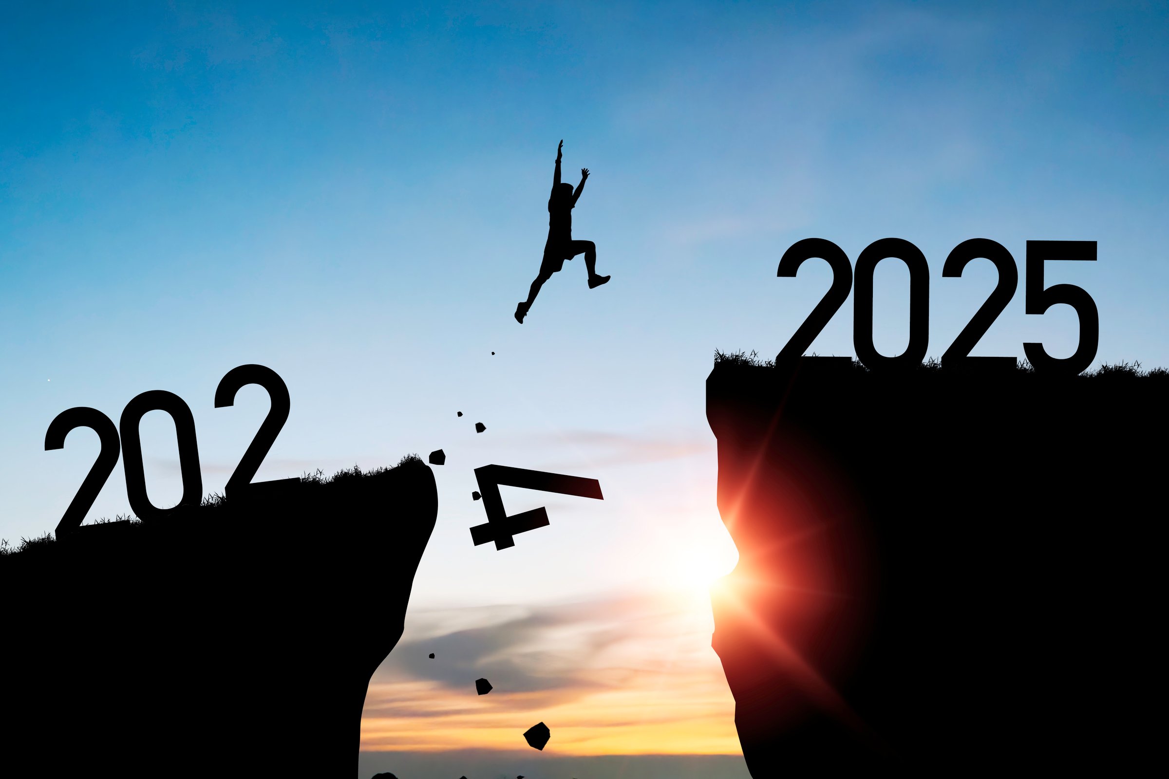 Welcome merry Christmas and happy new year in 2025,Silhouette Man jumping from 2024 cliff to 2025 cliff with cloud blue sky and sunlight.