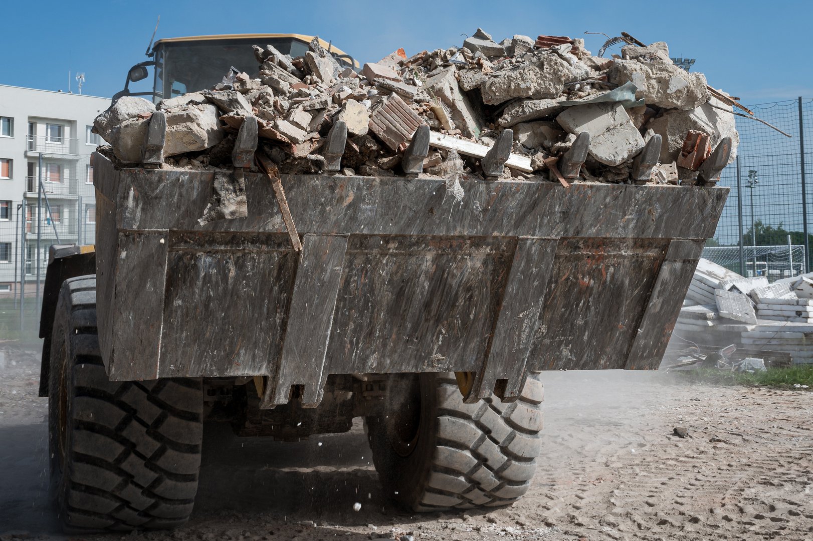 The loader is carrying rubble from the demolition of a building