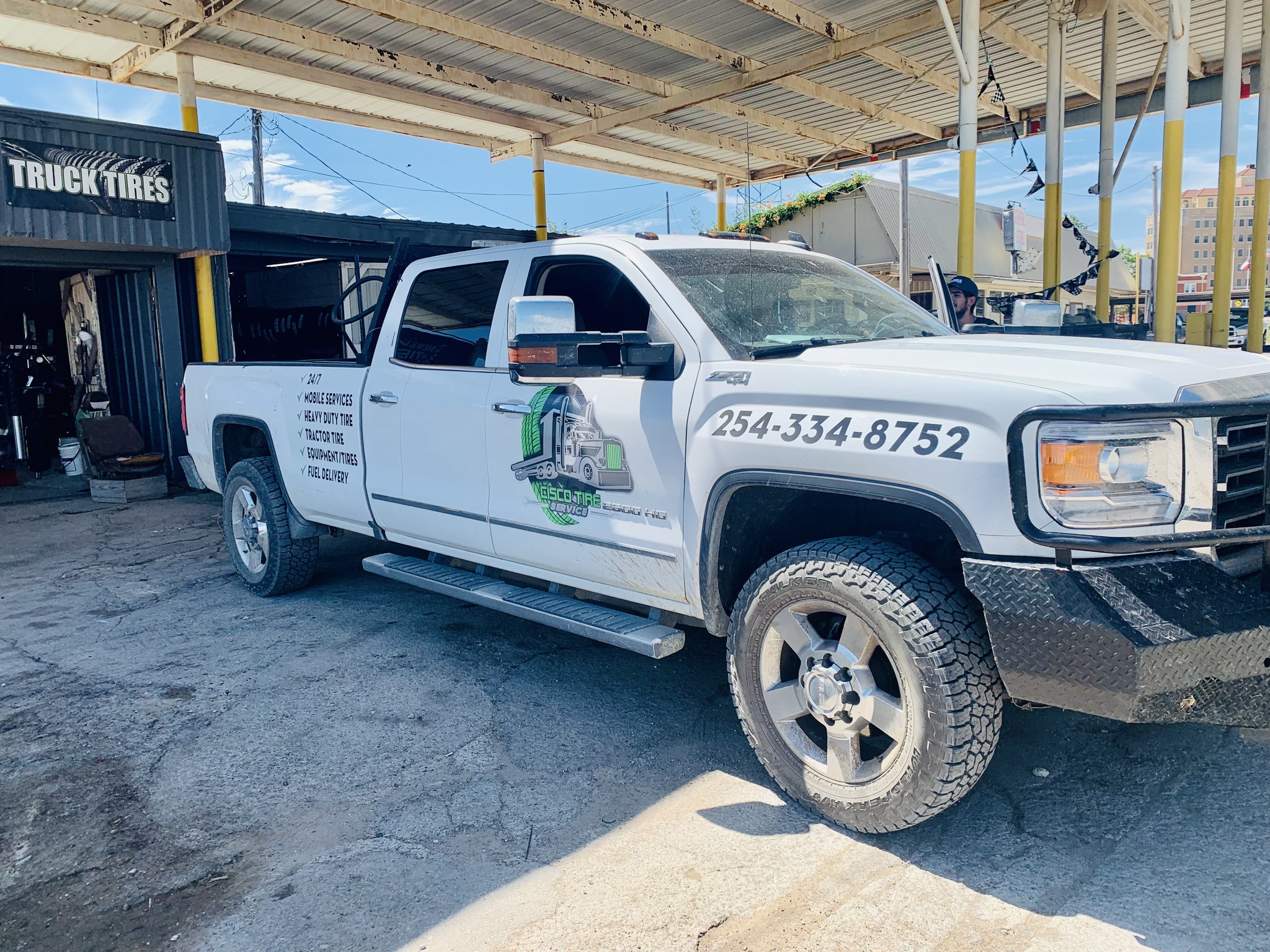 friendly auto mechanic handshaking with family inside workshop