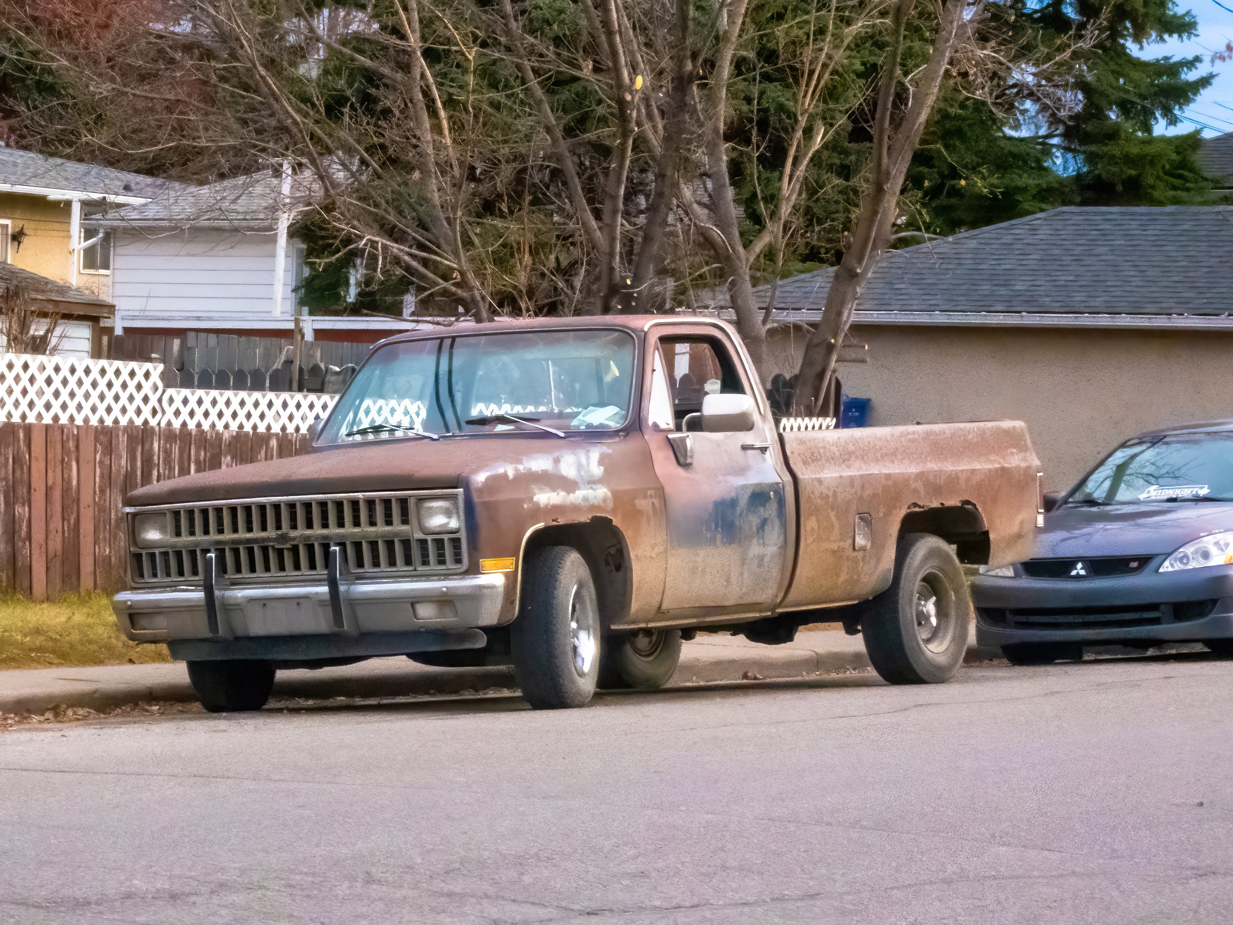 Calgary, AB, Canada. Nov 10, 2024. A weathered, rusty pickup truck, parked beside a residential street, stands as a testament to time and use.