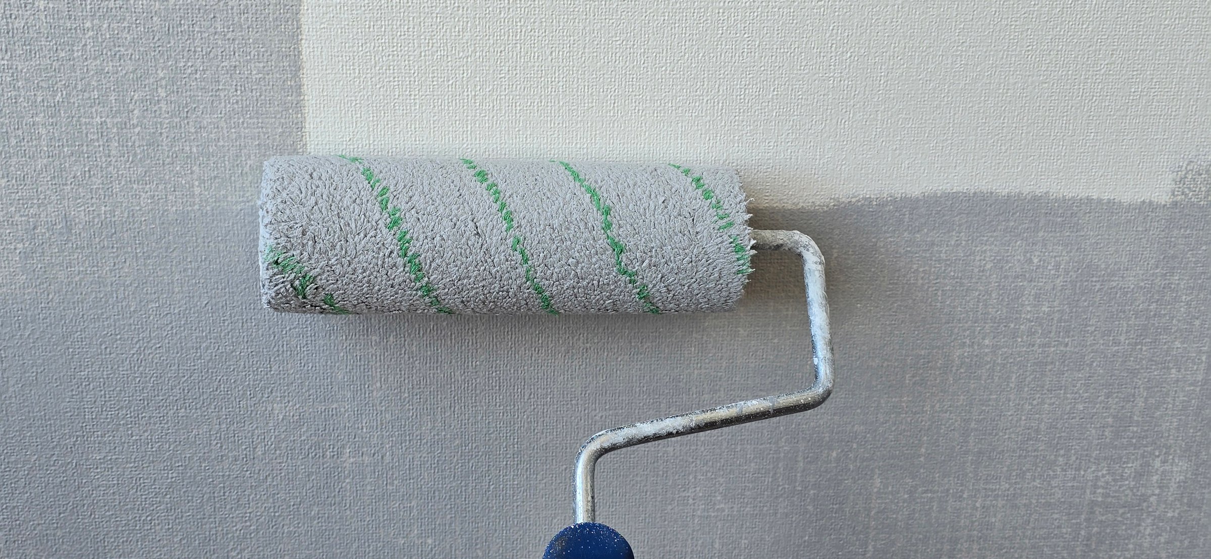 Paint roller applying fresh paint