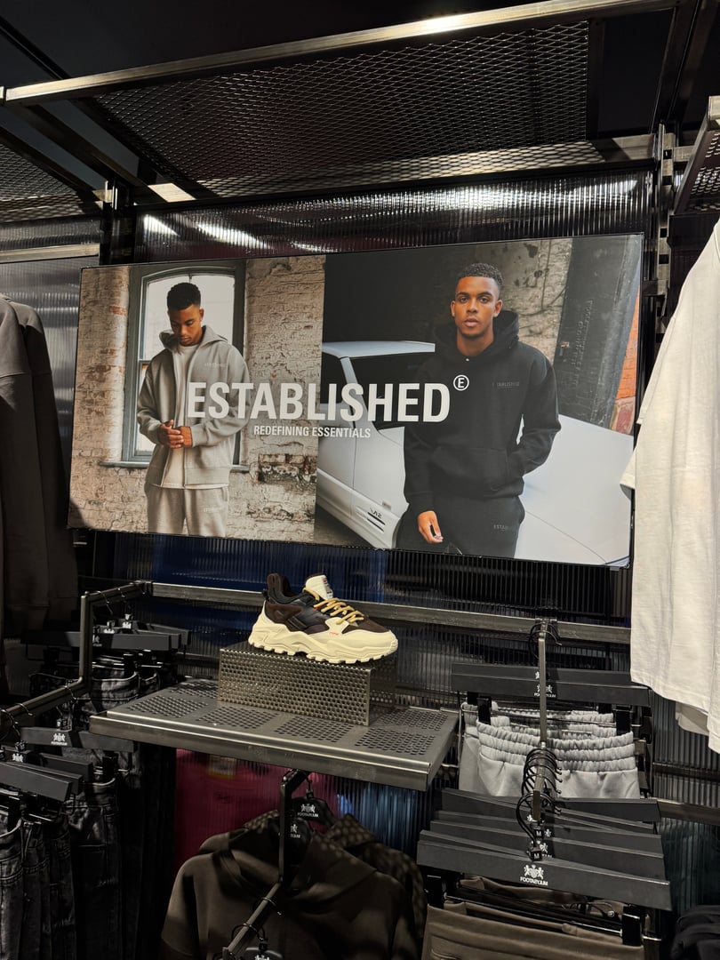Male fashion model wearing Footasylum Essentials tracksuit in retail store campaign