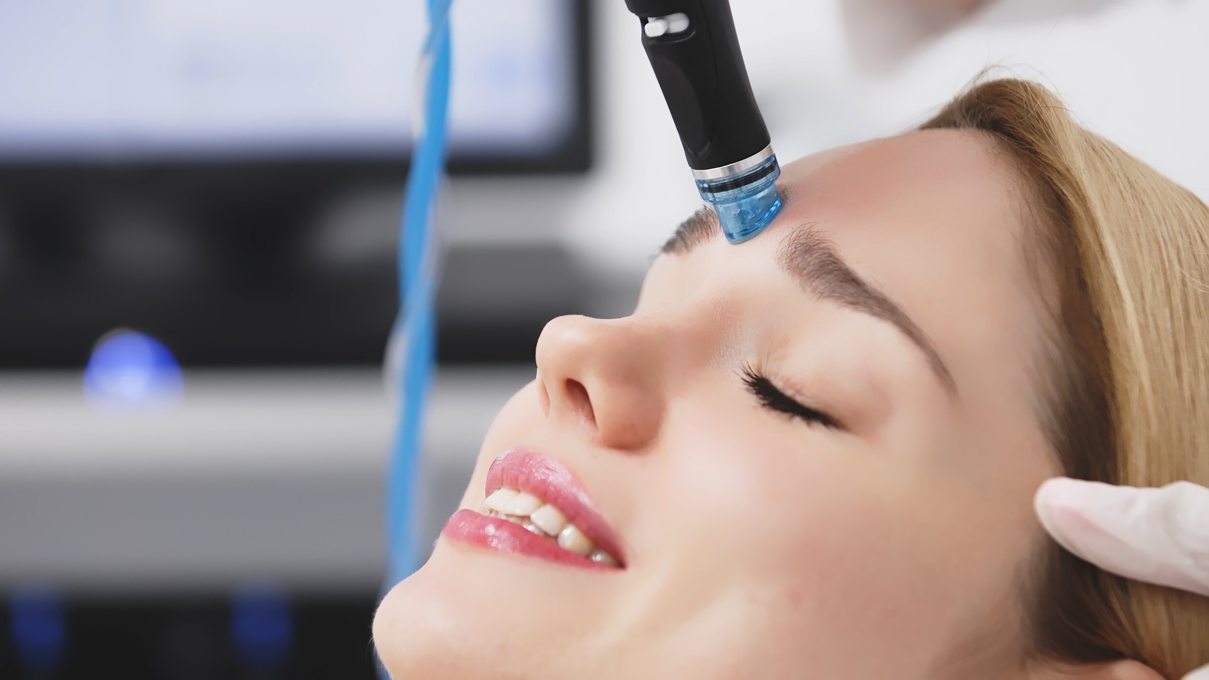 A cosmetologist performs hydropeeling, deeply cleansing and rejuvenating the client's skin in a modern clinic. Perfect for showcasing advanced beauty treatments and glowing skin results.