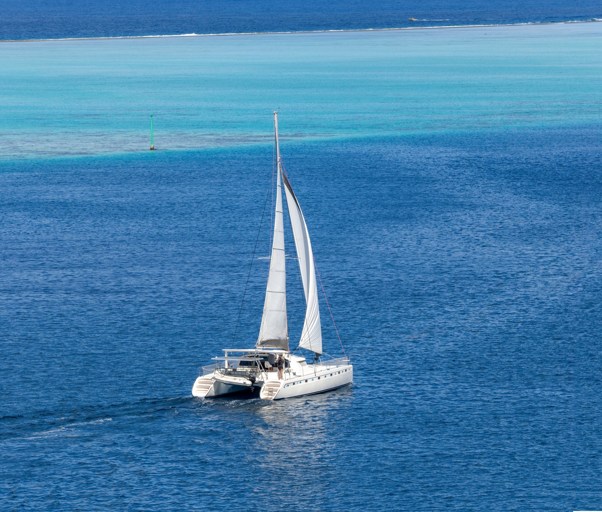 Catamaran sailing in the Raiatea lagoon, Society Islands, French Polynesia, South Pacific Ocean.