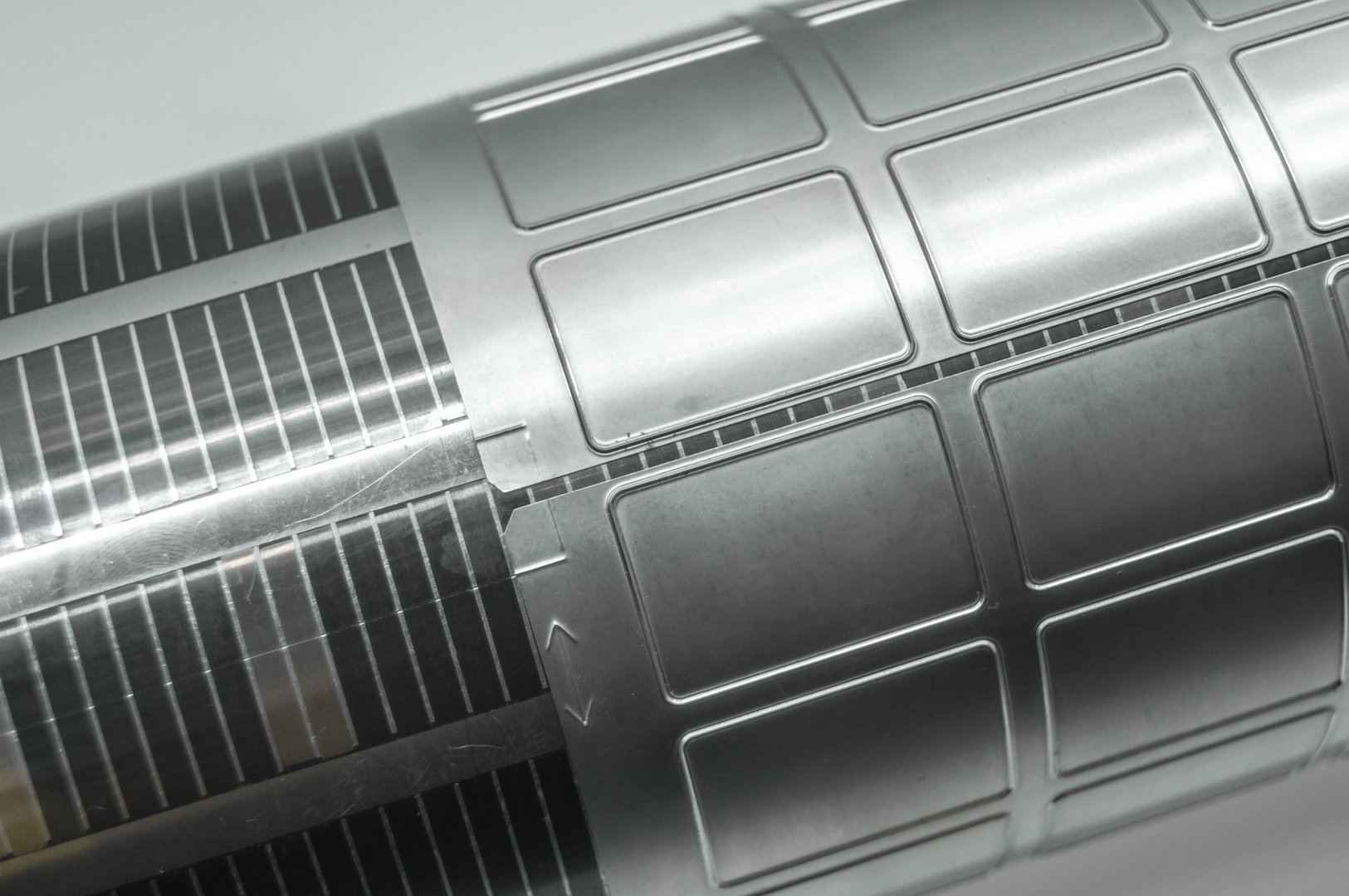 Used magnetic cylinder with attached flexible die for die cutting on rotary printing press. Die-cutting of labels. Cut knife for paper labels. Rotary stamp. Offset cutting knife for printing machine. Selective focus.