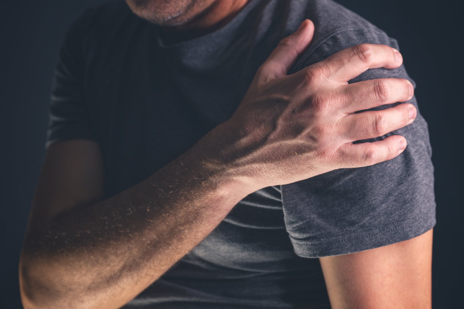 Aching frozen shoulder pain as symptom of rotator cuff tendinitis, adult caucasian male suffering from chronic bursitis, selective focus