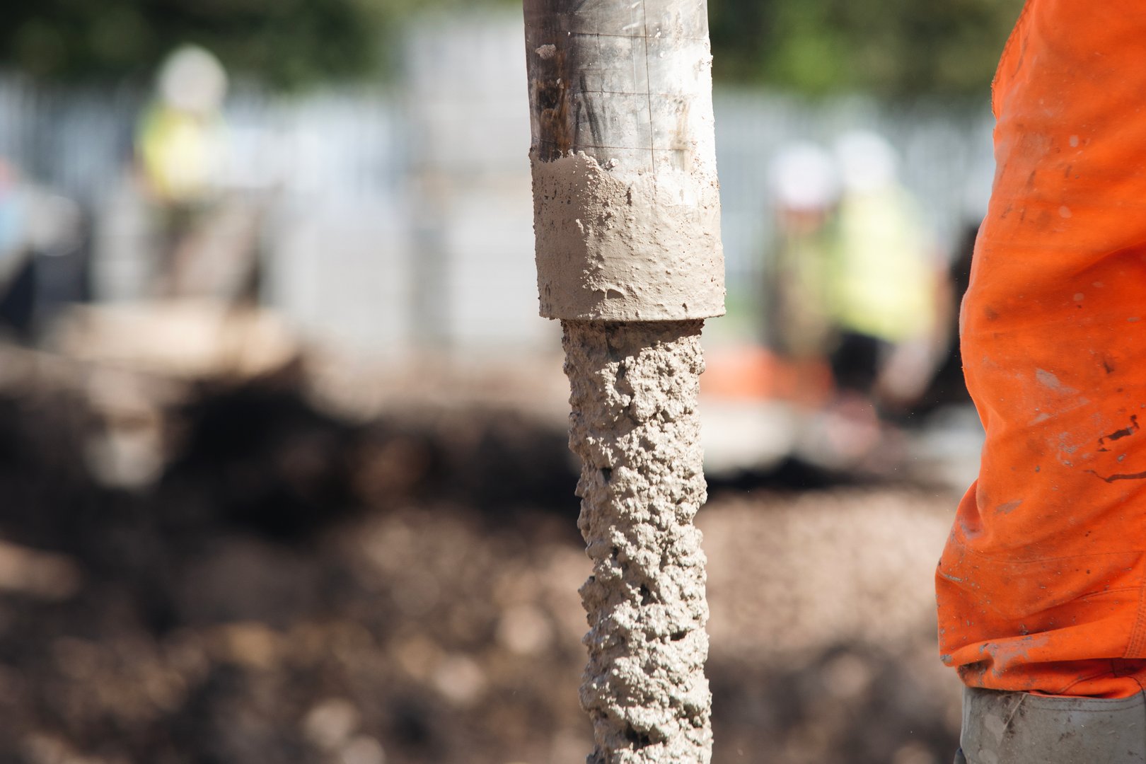 Close-up of Concreters builders using concrete pump to pour wet concrete at building site