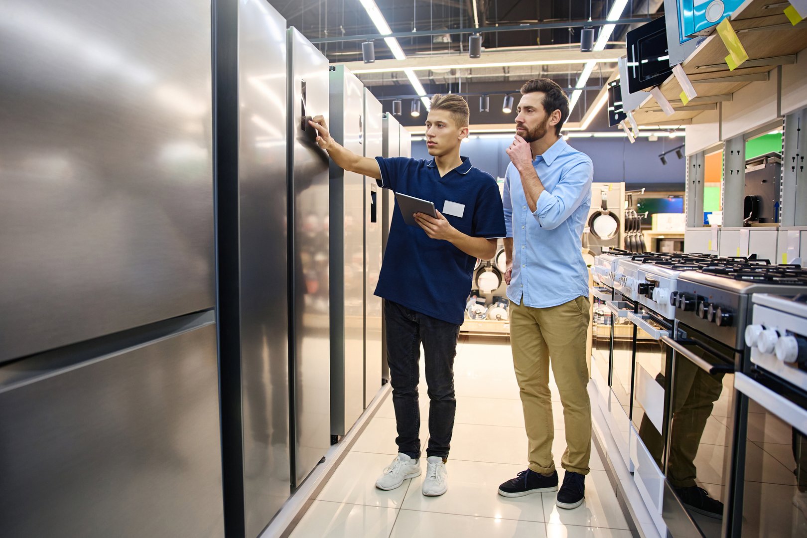 In a sleek and contemporary appliance showroom, a sales representative is passionately explaining features to a customer