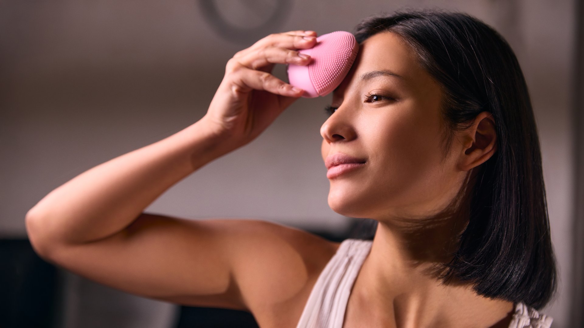 Woman using silicone facial cleansing brush