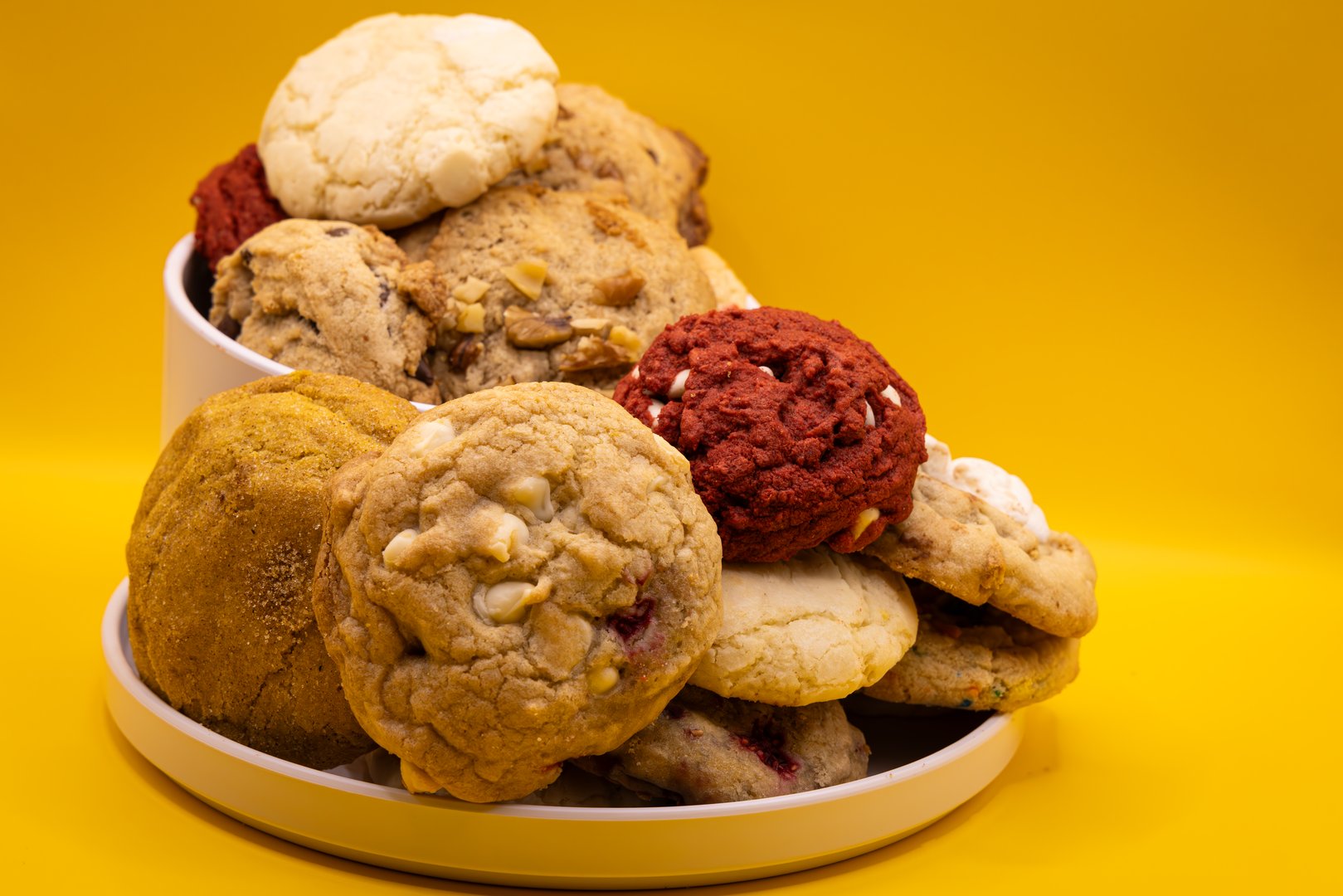 Overflowing bowl and plate full of cookies