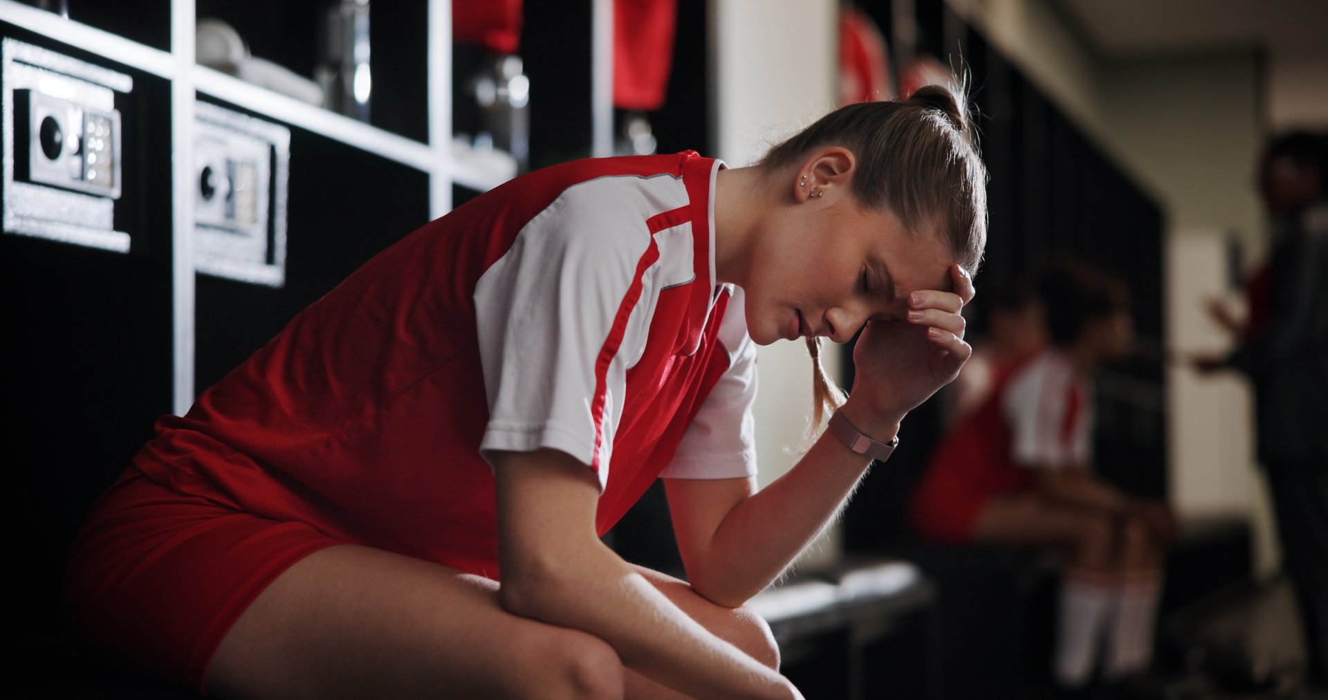 Frustrated female soccer player in locker room
