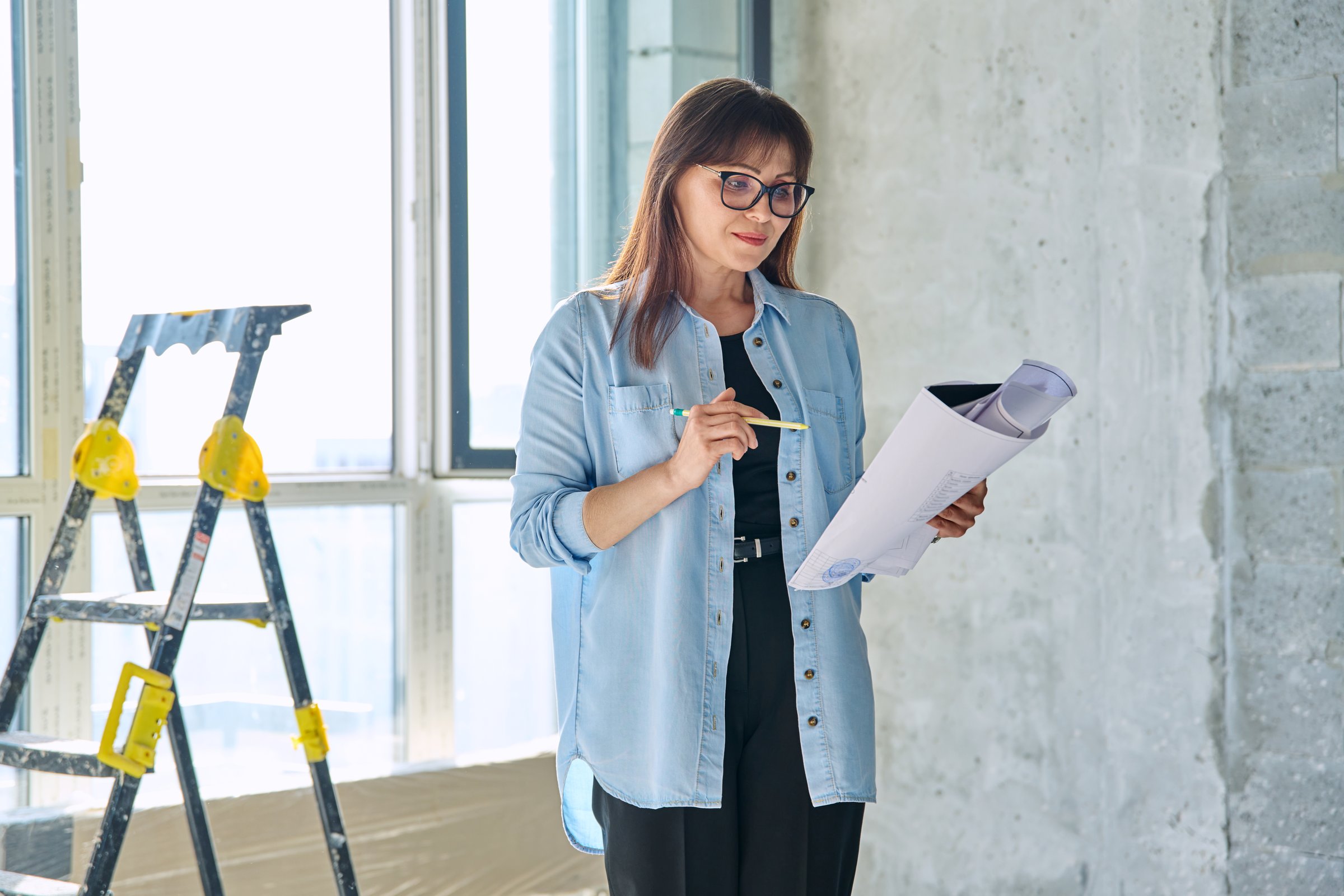 Female decorator designer, repair manager, organizer of final finishing and decor with blueprint drawing plan in new apartment house office. Repair, decoration, work, people concept