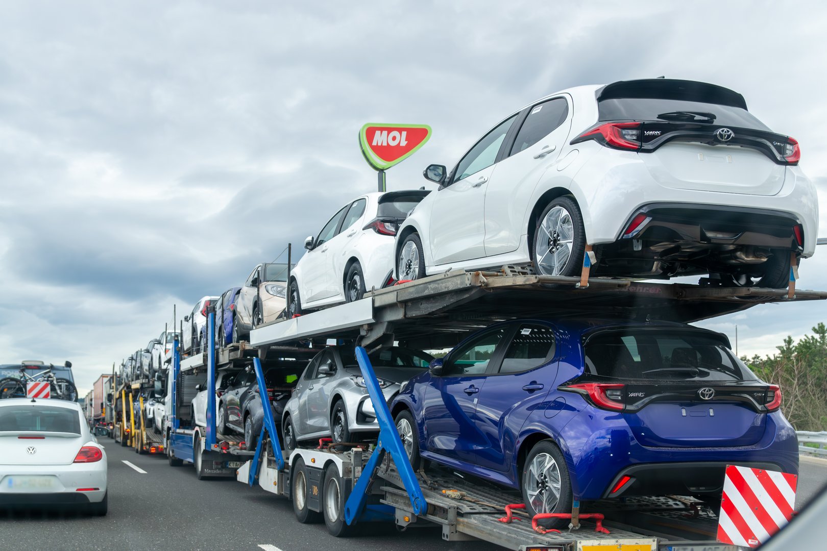Kozina, Slovenia- 25.04.2025: Car transporter truck carrying new Toyota vehicles on highway, rear view of auto transport trailer with compact cars
